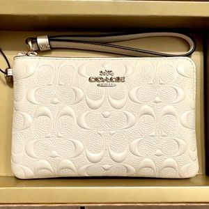 Authentic Coach signature embossed Chalk Wristlet with two charms